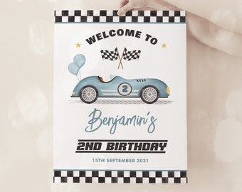 May include: A blue and white race car birthday party welcome sign with checkered flags and balloons. The sign says "Welcome to Benjamin's 2nd Birthday 15th September 2031".