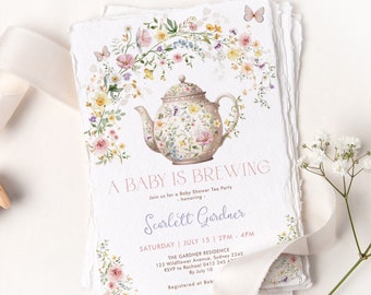 Op de afbeelding: Een baby shower uitnodiging met een bloemenontwerp met een theepot en vlinders. De tekst luidt "A Baby is Brewing" en bevat de naam "Scarlett Gardner" en de datum "July 15".