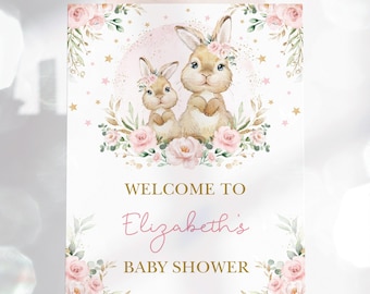 Könnte beinhalten: Willkommen zur Babyparty von Elizabeth Schild mit zwei Hasen, die Blumenkränze tragen und von rosa Rosen und goldenen Sternen umgeben sind.