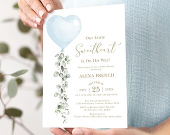May include: A blue and green baby shower invitation with a heart-shaped balloon and eucalyptus leaves. The text reads "Our Little Sweetheart Is On His Way!" and includes the date, time, and location of the event.  RSVP information and registry details are also included.