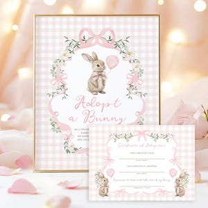 May include: A framed print and certificate featuring a bunny theme. The print has a pink gingham background with a bunny holding a balloon, surrounded by floral accents and the text "Adopt a Bunny." The certificate has a similar design.