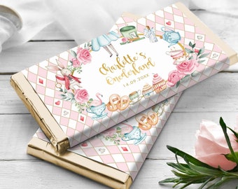 May include: A pink and white chocolate bar wrapper with a gold border. The wrapper features a watercolour illustration of Alice in Wonderland characters, including the Mad Hatter, the White Rabbit, and the Queen of Hearts. The text "Charlotte's Wonderland" and the date "14.09.20XX" are printed in gold.