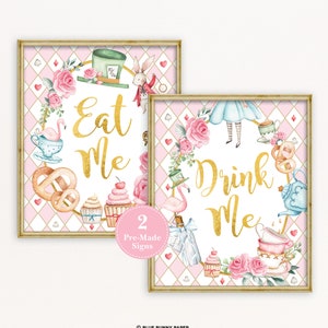 May include: Two printable Alice in Wonderland themed signs with pink and white backgrounds. The signs feature a gold wreath with various Alice in Wonderland themed illustrations and the text "Eat Me" and "Drink Me".