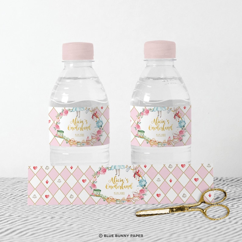 K&ouml;nnte beinhalten: Wasserflaschenetiketten im Alice-im-Wunderland-Thema in Rosa und Gold. Die Etiketten zeigen einen Blumengirlanden mit Alice und dem Hutmacher, sowie den Text "Alicia's Wonderland" und ein Datum.