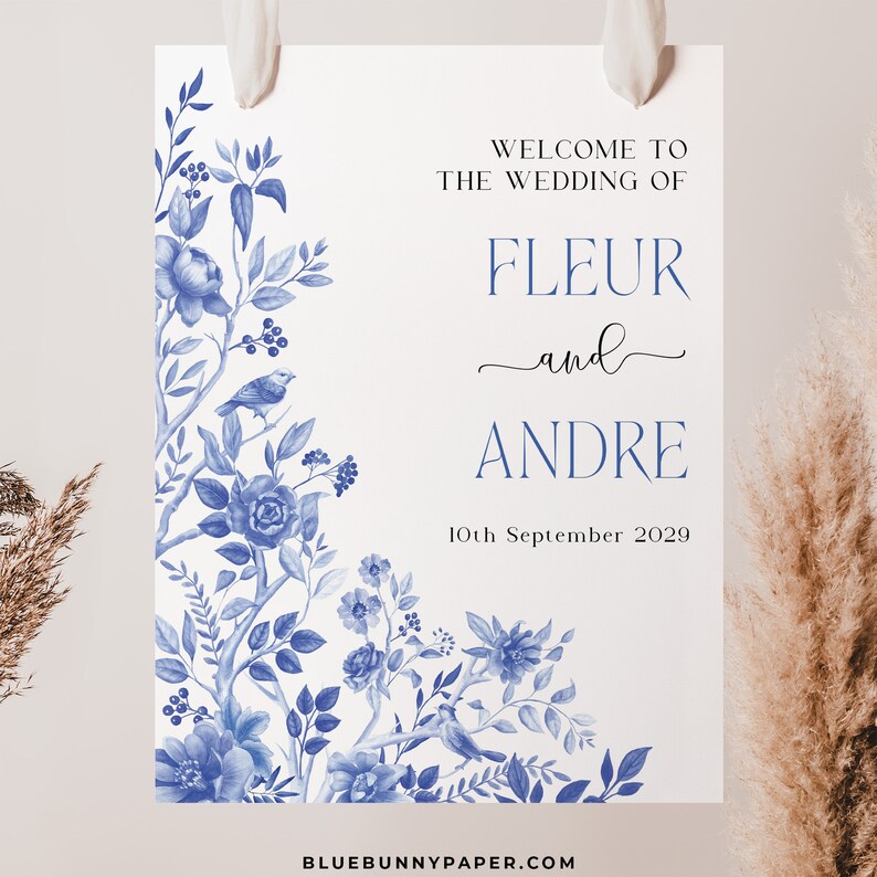 May include: A wedding welcome sign with a blue and white floral design. The text reads "Welcome to the wedding of Fleur and Andre, 10th September 2029".