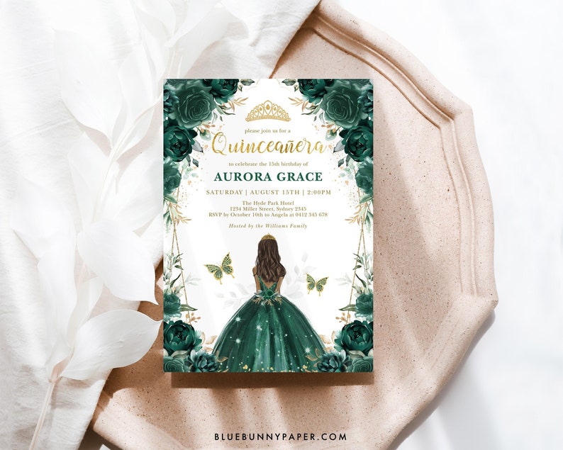 May include: A green and gold Quincea&ntilde;era invitation with a floral design and a silhouette of a girl in a green dress. The text on the invitation reads "Please join us for a Quincea&ntilde;era to celebrate the 15th birthday of Aurora Grace. Saturday | August 15th | 2:00PM. The Hyde Park Hotel. 1234 Miller Street, Sydney 2345. RSVP by October 10th to Angela at 0112 345 678. Hosted by the Williams family."