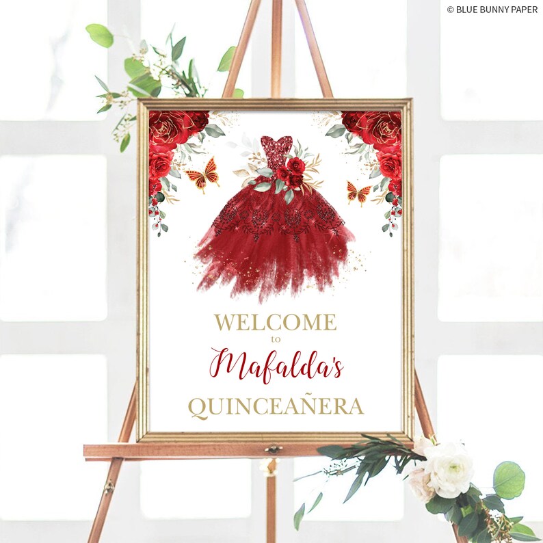 May include: Welcome to Mafalda's Quincea&ntilde;era sign with a red and gold design. The sign features a watercolor illustration of a red dress with gold glitter accents and butterflies.