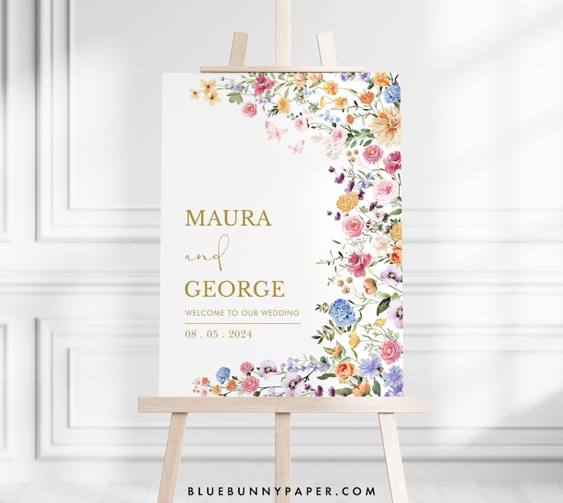 Pode incluir: Um cartaz de boas-vindas de casamento com uma borda floral em tons de rosa, roxo, azul, amarelo e laranja. O cartaz diz "Maura e George, Bem-vindos ao nosso casamento, 08.05.2024".