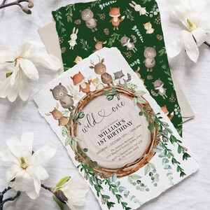 May include: A set of woodland-themed birthday invitations. The main invitation features a wood slice design with the text "wild & one" and event details. A matching green patterned card with woodland animals is also included.