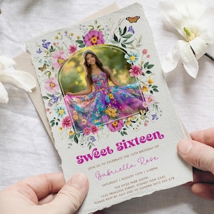 May include: A floral-themed invitation for a Sweet Sixteen party. The invitation features a photo of a young woman in a colorful dress, surrounded by pink, purple, and yellow flowers. The text on the invitation reads "Sweet Sixteen" and "Join us to celebrate the 16th birthday of Gabriella Rose".
