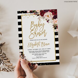 May include: A black and white striped baby shower invitation with gold glitter accents and a floral design. The invitation reads "Baby Shower" and "Please join us as we shower Elizabeth Brown". The invitation includes the date, time, location, RSVP information, and registry details.