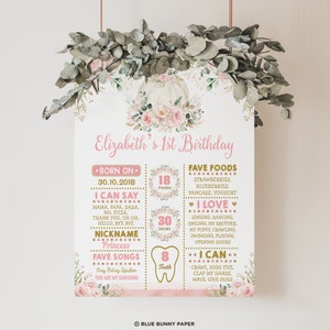 May include: A pink and gold first birthday milestone poster with a pumpkin and floral design. The poster includes details about the child's age, weight, height, and other milestones. The text on the poster reads "Elizabeth's 1st Birthday", "Born on 30.10.2018", "I can say", "Nickname Princess", "Fave Songs", "Fave Foods", "I Love", "I Can", "18 pounds", "30 inches", "8 teeth".