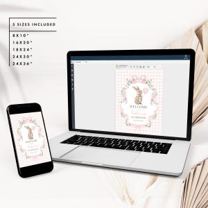 Peut inclure: Impression num&eacute;rique affich&eacute;e sur un ordinateur portable et un smartphone. L'impression pr&eacute;sente un lapin tenant un ballon rose, entour&eacute; d'une couronne florale, avec le texte "WELCOME Sabrina's 1st BIRTHDAY". Tailles incluses : 20x25cm, 41x51cm, 46x61cm, 61x76cm, et 61x91cm.