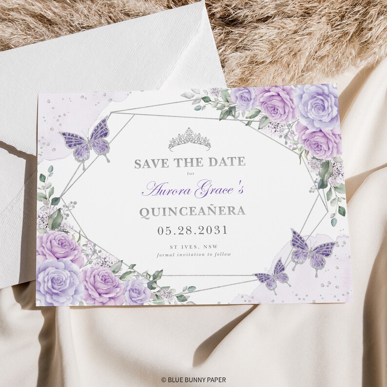 May include: Save the date card with a silver geometric frame decorated with purple and white watercolour roses and butterflies. The text reads "Save the Date for Aurora Grace's Quincea&ntilde;era 05.28.2031 ST IVES, NSW formal invitation to follow".