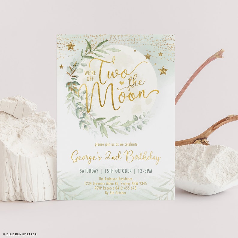 May include: A light blue and gold birthday invitation with a moon and stars design. The text reads "We're off to the moon" and "George's 2nd Birthday".