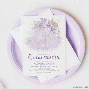 May include: Purple Quincea&ntilde;era invitation with a watercolor illustration of a lavender dress with floral accents. The text reads "Please join us for a Quincea&ntilde;era to celebrate the 15th birthday of Aurora Grace. Saturday, August 15th, 2:00 PM. The Hyde Park Hotel, 1254 Miller Street, Sydney 2545. RSVP by October 10th to Angela at 0412 345 678. Hosted by the Williams Family."