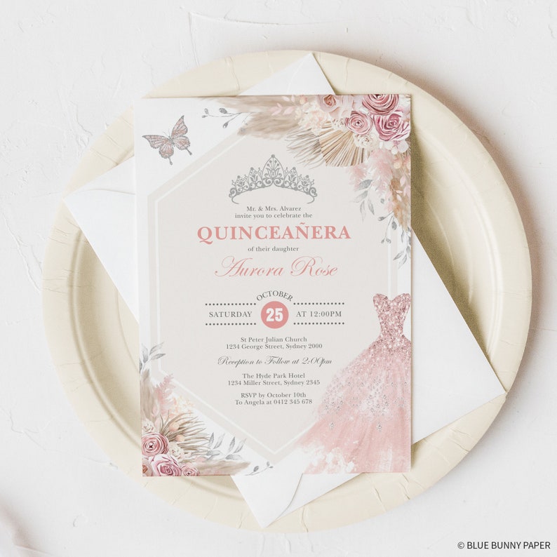 May include: A pink and white Quincea&ntilde;era invitation with a floral design and a crown. The invitation includes the text "Mr. & Mrs. Alvarez invite you to celebrate the Quincea&ntilde;era of their daughter Aurora Rose" and the date "October 25th".