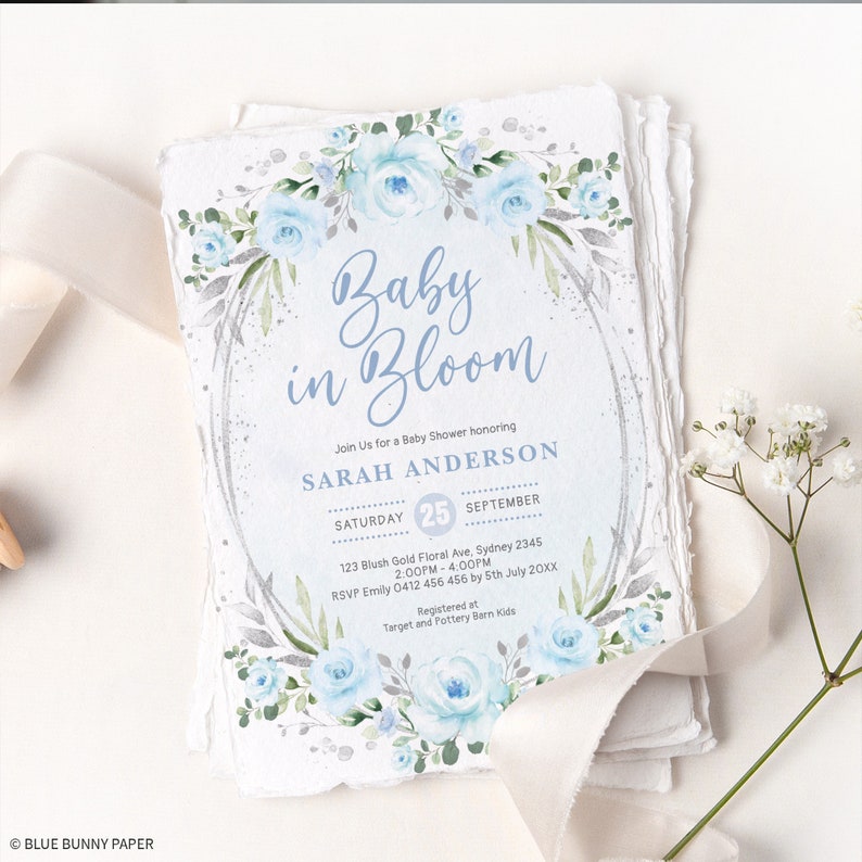 Peut inclure: Des invitations de baby shower avec un motif floral. Le texte "Baby in Bloom" est mis en &eacute;vidence, ainsi que les d&eacute;tails de la baby shower de Sarah Anderson. Le design comprend des roses bleu clair et des accents argent&eacute;s.