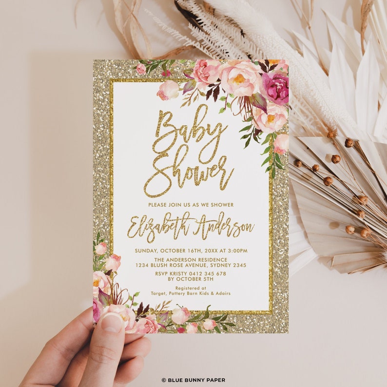 May include: Gold glitter baby shower invitation with pink and white floral design. The invitation reads "Baby Shower" and "Please join us as we shower Elizabeth Anderson". The invitation includes the date, time, location, RSVP information, and registry details.