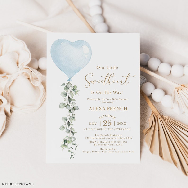 May include: A blue and white baby shower invitation with a blue heart balloon and eucalyptus leaves. The text reads "Our Little Sweetheart Is On His Way!" and includes the name "Alexa French", the date "November 25th, 20XX", and the time "2 o'clock in the afternoon".
