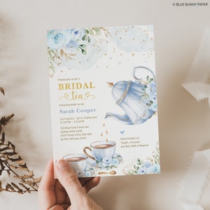 May include: A blue and gold bridal shower invitation with a watercolor illustration of a teapot and teacups. The invitation reads "Please join us for a Bridal Tea honoring bride-to-be Sarah Cooper" and includes the date, time, and RSVP information.
