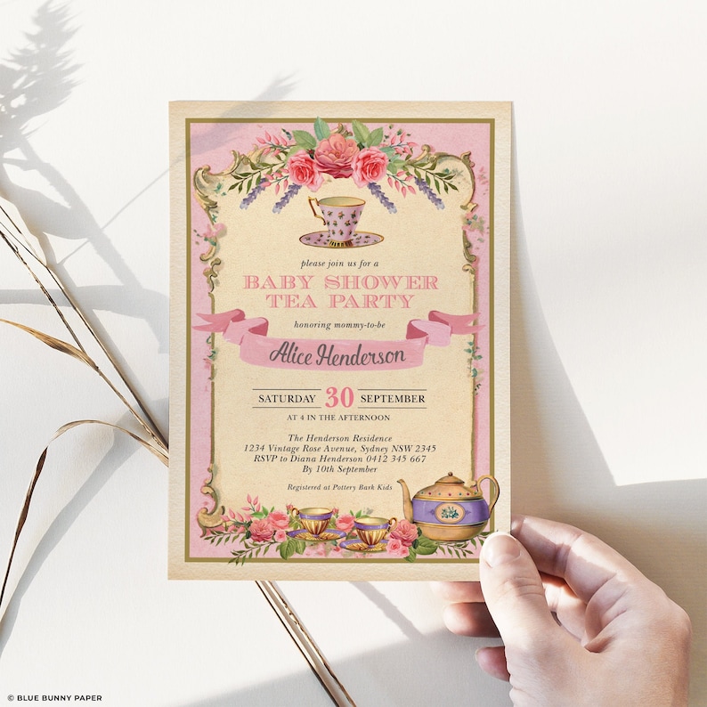 May include: A pink and gold baby shower invitation with a teacup and teapot design. The invitation reads "Please join us for a Baby Shower Tea Party honouring mummy-to-be Alice Henderson. Saturday, 30th September at 4 in the afternoon. The Henderson Residence, 1234 Vintage Rose Avenue, Sydney NSW 2345. RSVP to Diana Henderson 0412 345 667 by 10th September. Registered at Pottery Bark Kids."