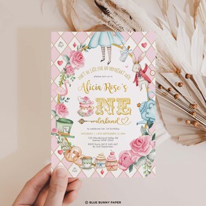 May include: A pink and gold Alice in Wonderland themed invitation with floral and character illustrations. The text reads "Alicia Rose's ONE-derland" and includes event details. The invitation is held by a hand.
