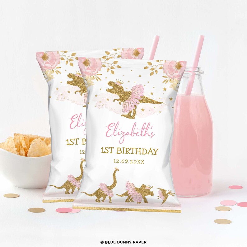 May include: Two white chip bags with pink and gold floral designs. The bags feature a gold glitter dinosaur wearing a pink tutu and a crown. The text on the bags reads "Elizabeth's 1st Birthday 12.09.20XX".