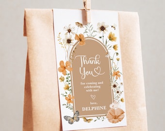 May include: A white thank you card with a floral border and a brown archway. The text reads "Thank You" with a heart symbol and "for coming and celebrating with me! love, DELPHINE".