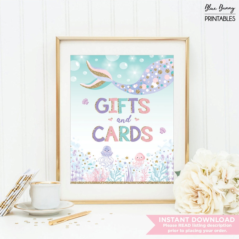 Puede incluir: Un cartel imprimible con una cola de sirena y el texto "*GIFTS and CARDS*" en purpurina rosa, morada y dorada. El fondo es azul claro con burbujas y criaturas marinas.