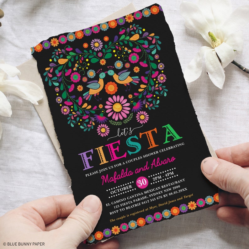 May include: A black invitation with a colorful floral heart design and the text "Let's Fiesta" in rainbow colors. The invitation is for a couples shower celebrating Mafalda and Alvaro. The event is scheduled for October 30th from 2 PM to 4 PM at El Camino Cantina Mexican Restaurant. The address is 125 Fiesta Parade, Sydney NSW 2000. RSVP to Beatriz at 0412 345 676 by 08.05.20XX. The couple is registered at Myer, David Jones and Target.