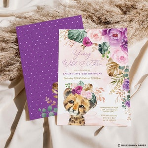 Op de afbeelding: Een paarse en roze bloemige verjaardagsuitnodiging met een cheeta-welpje dat een bloemenkrans draagt. De uitnodiging zegt "Young Wild & Three" en bevat de tekst "Savannah's 3rd Birthday" en "Saturday, 12th October at 12:00pm".