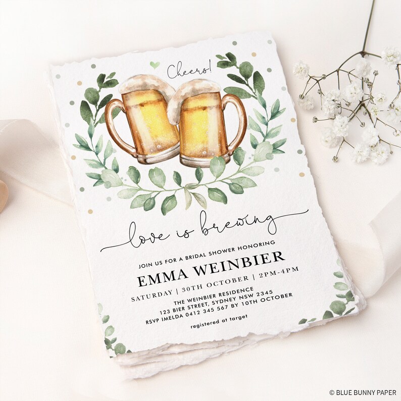 K&ouml;nnte beinhalten: Eine Aquarell-Illustration von zwei Bierkr&uuml;gen mit gr&uuml;nen Bl&auml;ttern und dem Text "love is brewing" auf wei&szlig;em Hintergrund. Der Text "Join us for a bridal shower honoring Emma Weinbier" befindet sich unter der Illustration. Datum und Uhrzeit der Veranstaltung sind unter dem Namen aufgef&uuml;hrt. Der Text "The Weinbier Residence" ist unter dem Datum und der Uhrzeit aufgef&uuml;hrt. Die Adresse und die RSVP-Informationen sind unter der Residenz aufgef&uuml;hrt. Der Text "registered at target" ist unter den RSVP-Informationen aufgef&uuml;hrt.