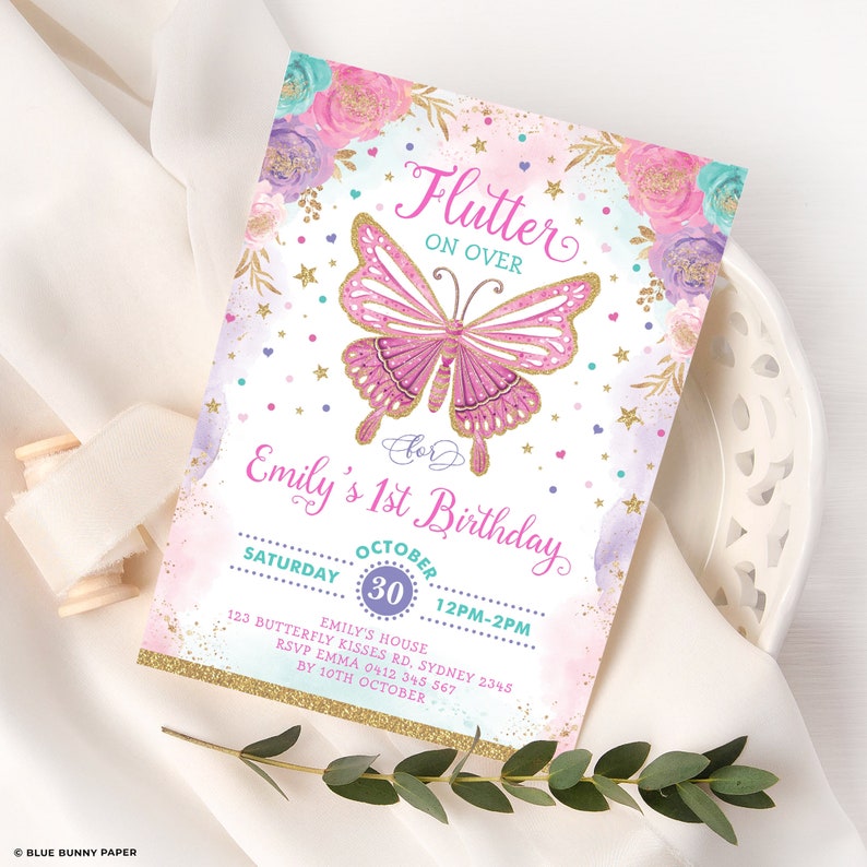 May include: A pink and gold butterfly with glitter accents on a white background. The text "Flutter On Over" is above the butterfly. The text "For Emily's 1st Birthday" is below the butterfly. The text "Saturday October 30 12PM-2PM" is below the birthday text. The text "Emily's House 123 Butterfly Kisses Rd. Sydney 2345 RSVP Emma 0412 345 567 By 10th October" is below the date and time.