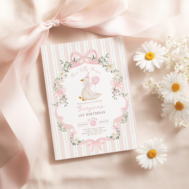 K&ouml;nnte beinhalten: Eine rosa-wei&szlig; gestreifte Geburtstagseinladungskarte mit floralem und Schleifendesign. Die Karte zeigt eine Cartoon-Gans, die einen Ballon h&auml;lt, und den Text "Georginas 1. Geburtstag". Wei&szlig;e G&auml;nsebl&uuml;mchen und ein rosa Band sind ebenfalls im Bild.