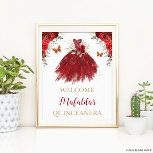 May include: Welcome to Mafalda's Quincea&ntilde;era sign with a red and gold watercolor illustration of a dress with butterflies and flowers.