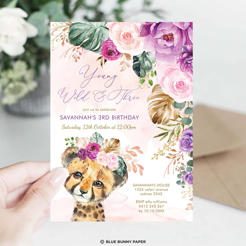Op de afbeelding: Een roze en paarse bloemen uitnodiging met een cheeta puppy die een bloemenkrans draagt. De uitnodiging luidt "Young Wild & Three" en is voor Savannah's 3e verjaardag. Het feest is op zaterdag 12 oktober om 12:00 uur. RSVP naar Ella Williams voor 10 oktober.