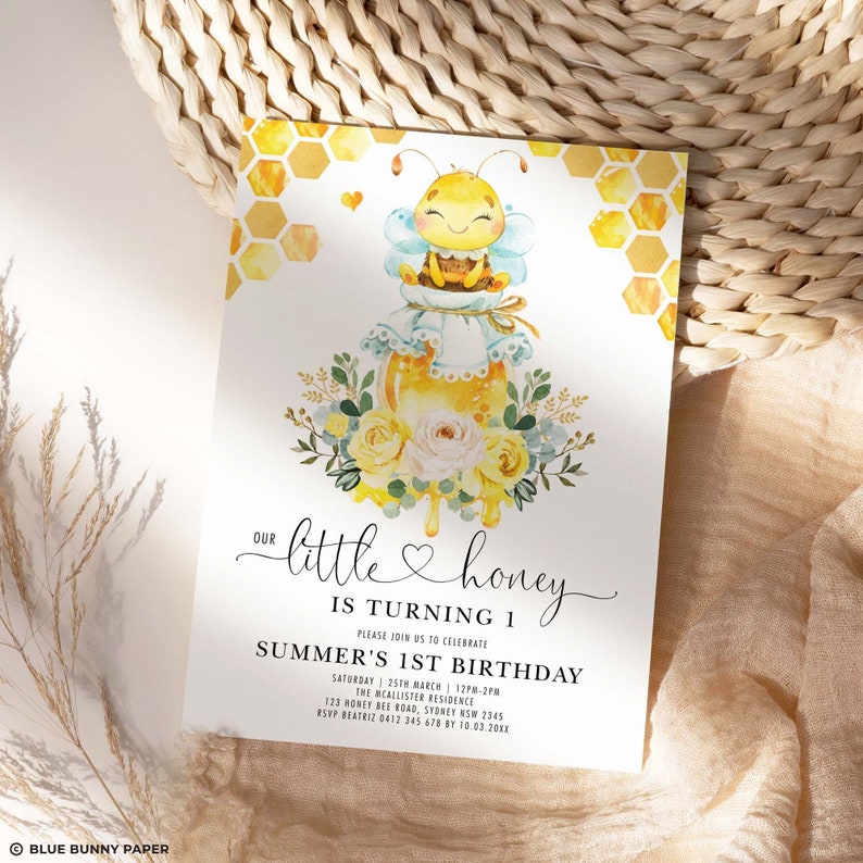 May include: A watercolour invitation with a bee theme. The invitation features a cartoon bee on a honey jar, surrounded by flowers and honeycomb patterns. Text reads "Our little honey is turning 1" and includes event details.