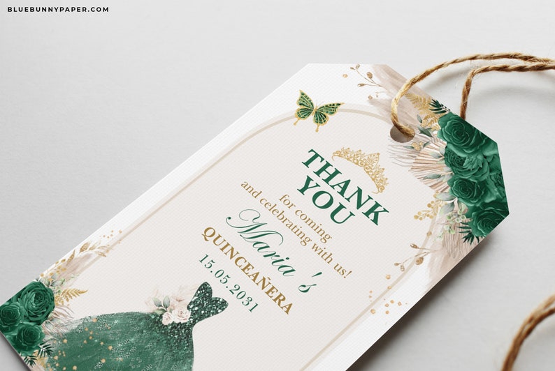 May include: A Quincea&ntilde;era thank you tag with a green and gold design. The tag features the text "THANK YOU" and "Maria's Quincea&ntilde;era 15.05.2031". It is decorated with a butterfly, a crown, and floral elements.
