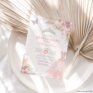 May include: A pink and gold Quincea&ntilde;era invitation with a floral design and a butterfly. The invitation includes the date, time, and location of the event. It also includes the name of the celebrant, Aurora Rose.