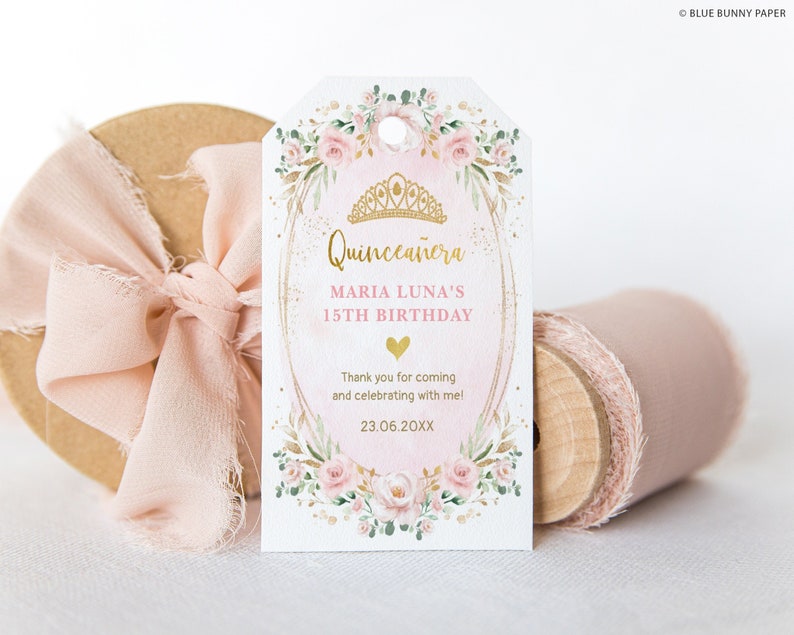 May include: A pink and gold Quincea&ntilde;era favor tag with a floral design and a crown. The text reads "Quincea&ntilde;era Maria Luna's 15th Birthday Thank you for coming and celebrating with me! 23.06.20XX"