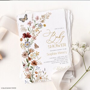 May include: A floral baby shower invitation with a gold script font. The invitation features a watercolor illustration of a bouquet of flowers with butterflies. The text reads "Join us for a Baby Shower Honoring Mommy-to-be Sophia Henry Saturday 1 April 10th 2PM The Wildflower Inn 124 Spring Blooms Ave. Sydney 2243 RSVP Olivia 0412 345 667 By April 5th"