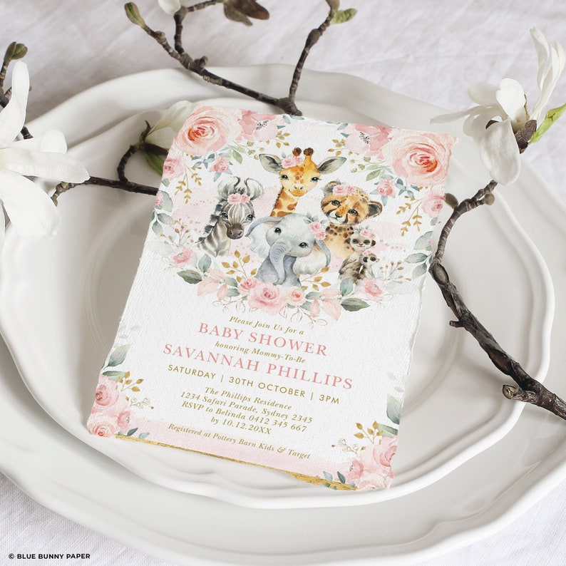 May include: A pink and gold baby shower invitation with a floral wreath and illustrations of a giraffe, zebra, elephant, cheetah, and monkey. The text reads "Please Join Us for a Baby Shower honouring Mommy-To-Be SAVANNAH PHILLIPS Saturday 30th October | 3PM The Phillips Residence 1234 Safari Parade, Sydney 2345 RSVP to Belinda 0412 345 667 by 10.12.20XX Registered at Pottery Barn Kids & Target"