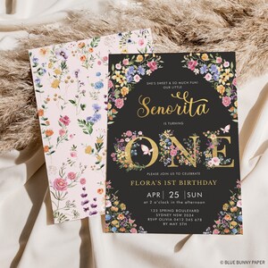 May include: A floral-themed first birthday invitation for a girl named Flora. The invitation features a black background with gold lettering and a large number "ONE" decorated with colourful flowers. The text reads "She's sweet & so much fun! Our little Senorita is turning one. Please join us to celebrate Flora's 1st birthday. Apr 25 Sun at 2 o'clock in the afternoon. 123 Spring Boulevard Sydney NSW 2034. RSVP Olivia 0412 345 678 by May 5th. &copy; Blue Bunny Paper."