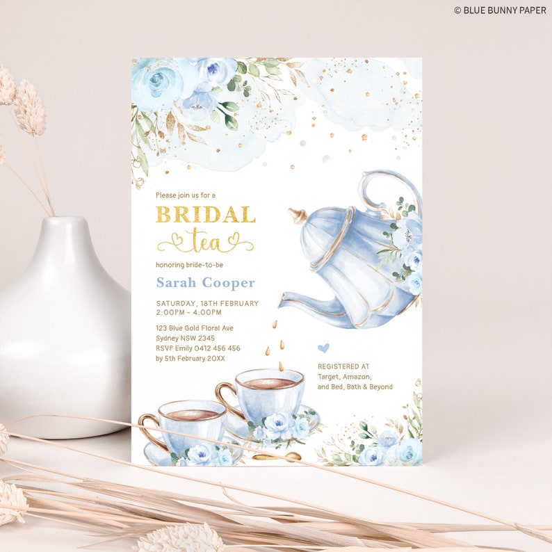 May include: A blue and gold bridal shower invitation with a teapot pouring tea into cups. The invitation features a watercolor background with blue flowers and gold glitter. The text on the invitation reads "Please join us for a Bridal Tea honoring bride-to-be Sarah Cooper Saturday, 18th February 2:00PM - 4:00PM 123 Blue Gold Floral Ave Sydney NSW 2345 RSVP Emily 0412 456 456 by 5th February 20XX Registered at Target, Amazon, and Bed, Bath & Beyond &copy; BLUE BUNNY PAPER"