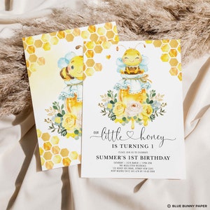 May include: Two invitation cards with a watercolour design. The cards feature a cute bee character on a honey jar, surrounded by flowers. The text reads "Our little honey is turning 1" and includes event details.