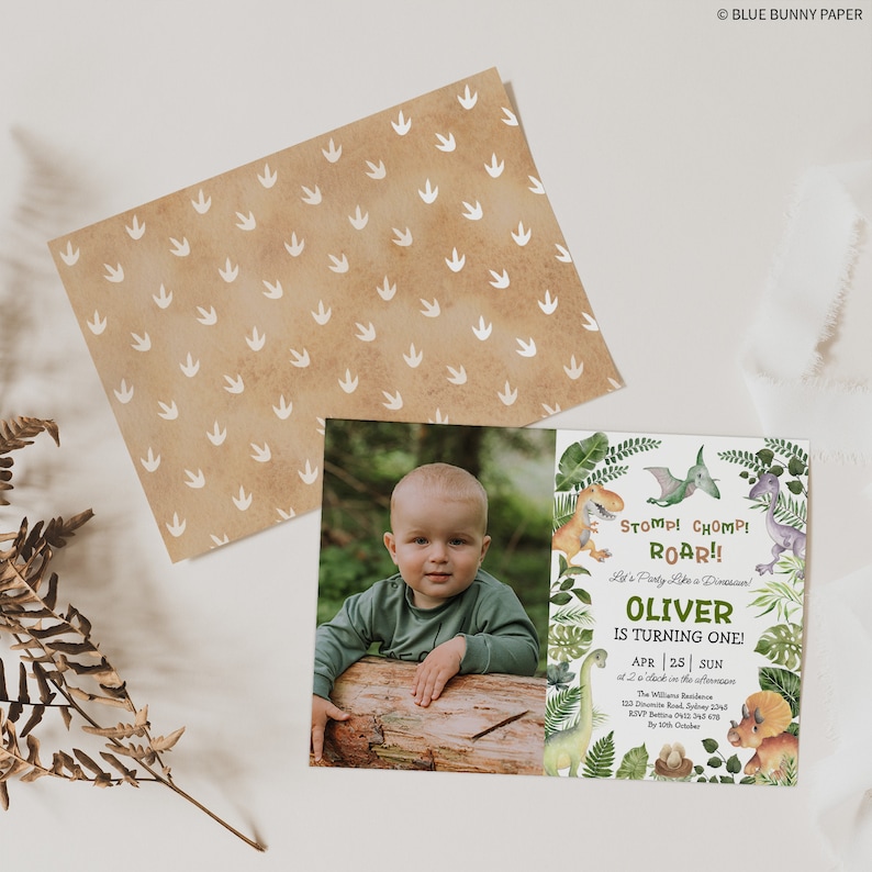 May include: A green and brown dinosaur-themed birthday invitation with a photo of a young boy. The invitation says "Stomp! Chomp! Roar!! Let's Party Like a Dinosaur! Oliver is Turning One!" with the date and time of the party.