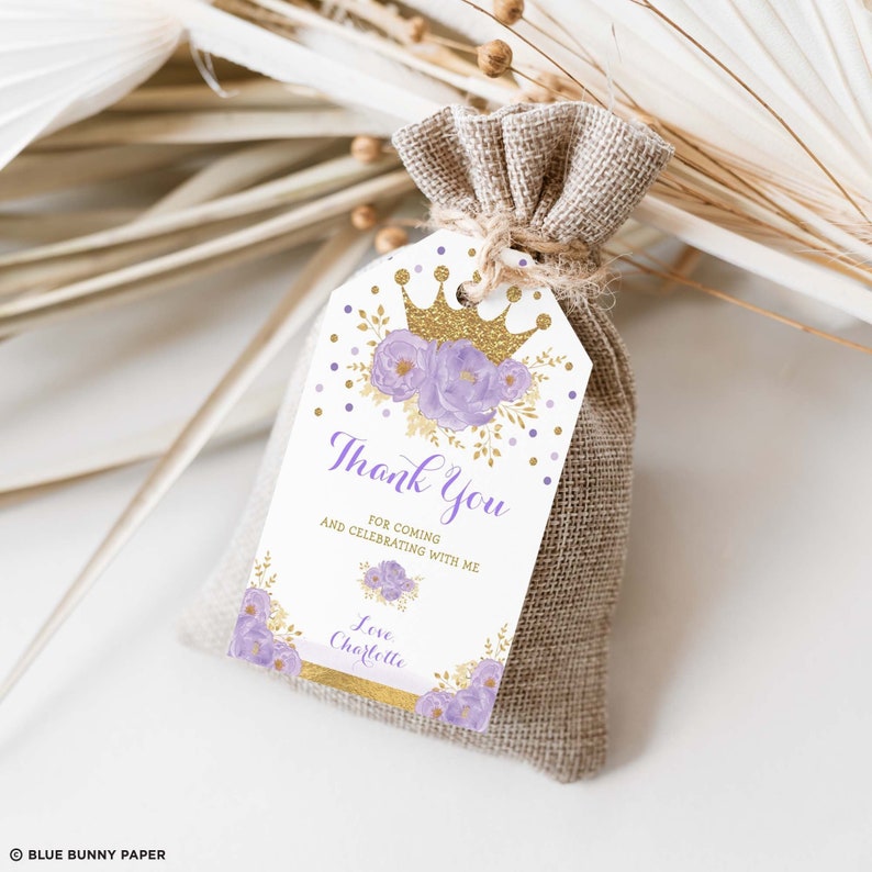 May include: Purple and gold thank you favor bag tag with a crown, flowers, and gold glitter. The text reads "Thank You for coming and celebrating with me. Love Charlotte."