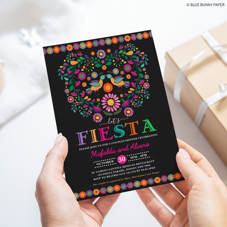 May include: A black and colorful invitation for a couples shower. The invitation features a heart-shaped floral design with birds and the text "Let's Fiesta" in rainbow colors. The text "Please join us for a couples shower celebrating Mafalda and Alvaro" is printed in white. The date and time of the event are listed as "October 30, 2PM-4PM". The location is "El Camino Cantina Mexican Restaurant, 125 Fiesta Parade, Sydney NSW 2000". The RSVP information is "RSVP to Beatriz 6412 345 676 by 08.05.20XX". The bottom of the invitation reads "The couple is registered at Myer, David Jones and Target".