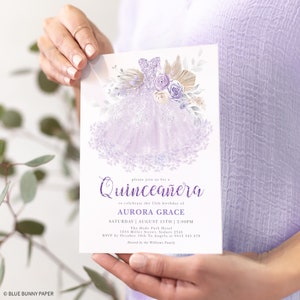 May include: Purple Quincea&ntilde;era invitation with a watercolor illustration of a lavender dress, flowers, and greenery. The text reads "Please join us for a Quincea&ntilde;era to celebrate the 15th birthday of Aurora Grace. Saturday, August 15th, 2:00 PM. The Hyde Park Hotel, 1234 Miller Street, Sydney 2545. RSVP by October 10th to Angela at 0412 345 678. Hosted by the Williams Family."